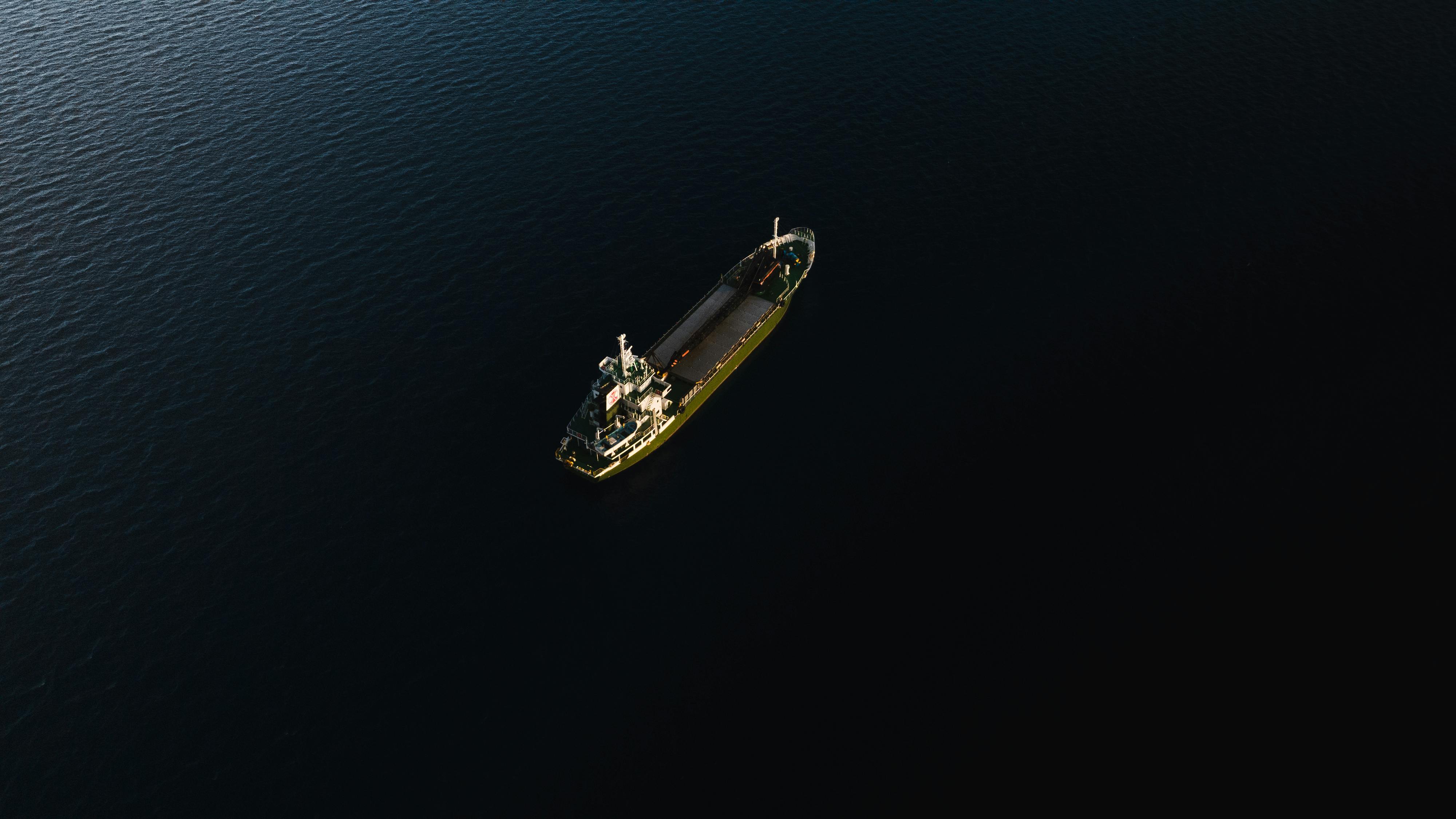 Aerial view of a ship crossing dark water